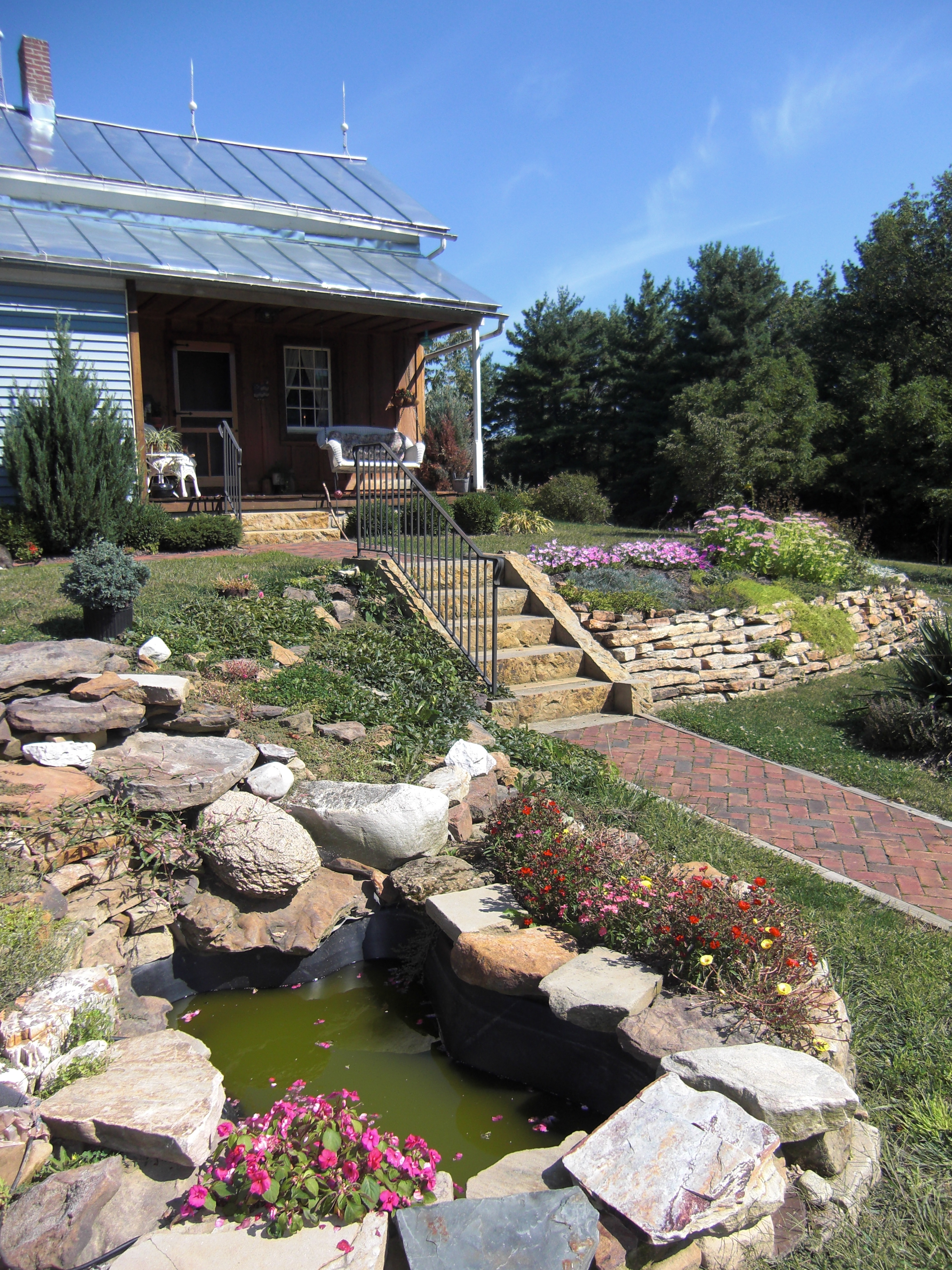 A small pond and steps leading up to a blue house