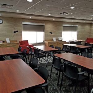 A conference room meeting space with tables and chairs set up in rows